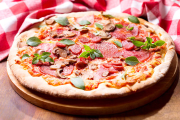 pizza with salami, ham and vegetables
