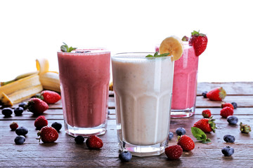 Glasses of fresh cold smoothie with fruit and berries, isolated on white