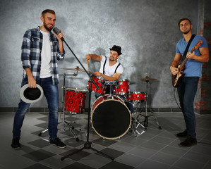 Musicians playing musical instruments and singing songs in a studio