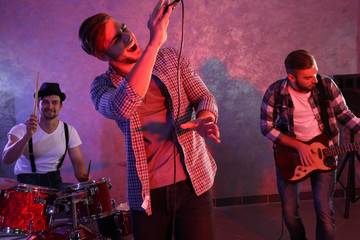 Musicians playing musical instruments and singing songs in a studio