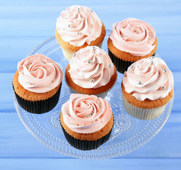 Tasty cupcakes on color wooden background