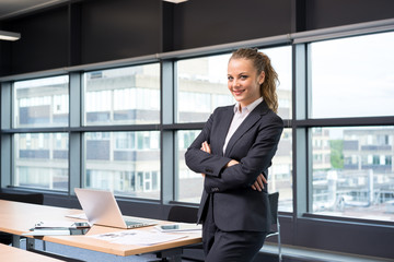 Businesswoman working & sitting at her desk in an office