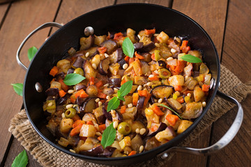 Italian Caponata with frying pan on a wooden background
