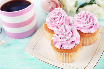 Tasty cupcakes on plate, on light background