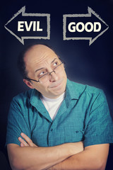 Adult man choosing between GOOD and EVIL
