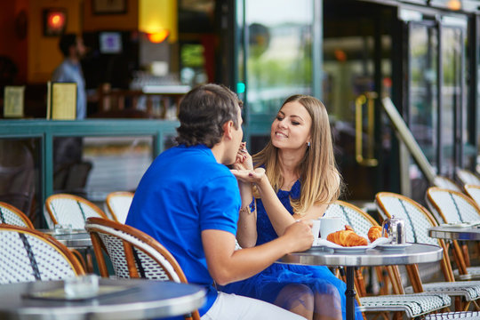 Beautiful young dating couple in Parisian cafe