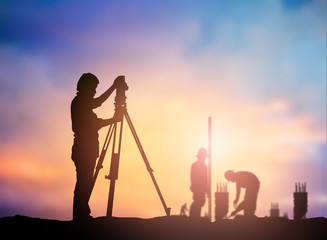 silhouette survey engineer working  in a building site over Blur - obrazy, fototapety, plakaty