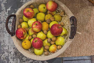 Apples, pears and nuts in a wicker basket. Top view