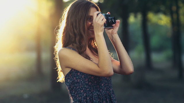 young female takes pictures with an old camera slow motion