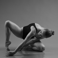 Modern ballet dancer posing on dark background