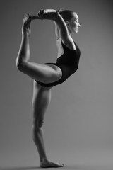 Modern ballet dancer posing on dark background