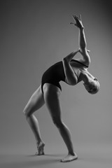 Obraz premium Modern ballet dancer posing on dark background