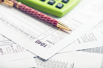 Calculating numbers for income tax return with pen, glasses and