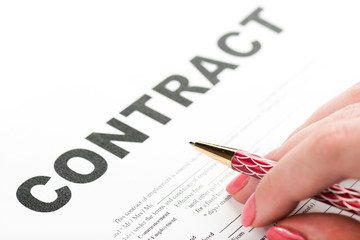 Businesswoman's hand with pen signing a contract.