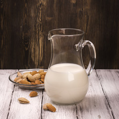 Almond milk in a glass jar over wooden background. Selective focus, toned image