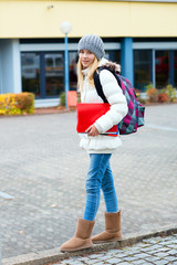 blond girl in front of school building