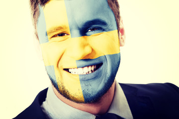 Happy man with Sweden flag on face.