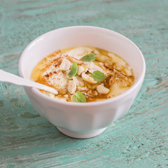 healthy food - natural yoghurt with honey, nuts and cinnamon in a white bowl on blue wooden surface