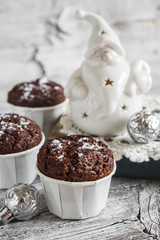 chocolate muffins and ceramic Santa Claus on a light wooden surface, vintage style