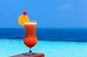 Glass of drink is on a beach table