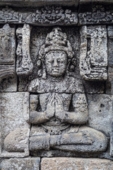 Fototapeta na wymiar Buddha bas-reliefs at the walls of Borobudur temple