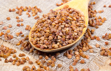 Buckwheat groats on a wooden spoon.