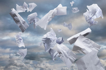 Waste paper caught by the wind, blows up into the sky overhead