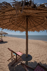 Morning beach with umbrellas made of palm leaves