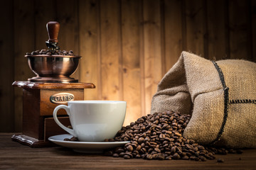 stillleben mit kaffeebohnen und alter kaffeemühle auf dem hölzernen hintergrund