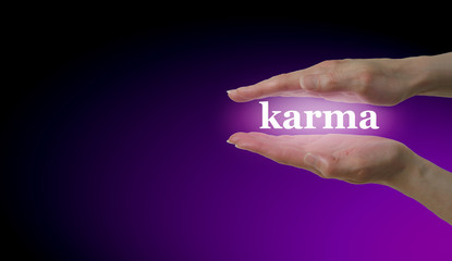 Your Karma is in Your Hands - Female hand parallel with the word 'Karma' floating between on a magenta and black background with plenty of copy space