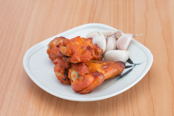 Chicken wings in dish on wooden table.