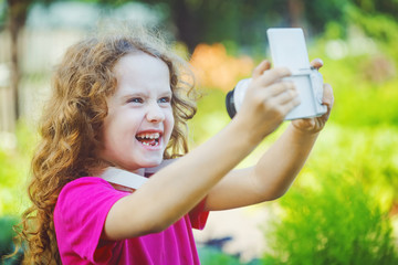 Naklejka premium Laughing girl taking selfie with photo camera.