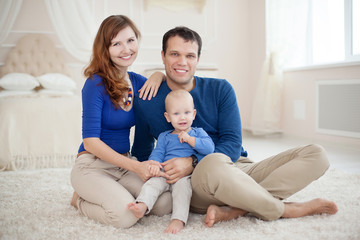 Home portrait of happy young family.