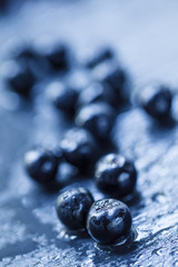 Chokeberry, bilberry on a wet stone background, selective focus