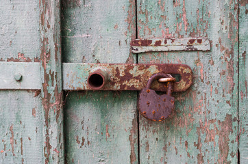 Detail of old wooden door with rusty padlock
