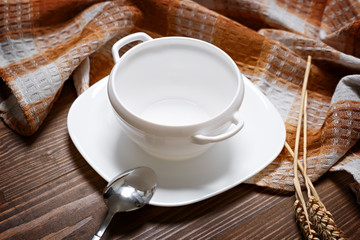 Empty cup of soup on a wooden table.