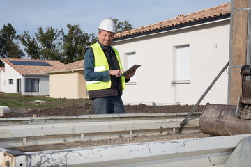 Construction engineer with tablet PC near  building