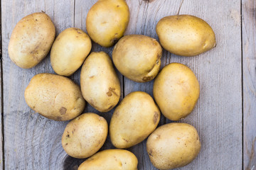 Raw potatoes on grunge wooden background