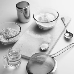 Suet pastry making ingredients and utensils on a kitchen worktop.