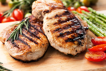grilled pork chop with vegetable on wooden board