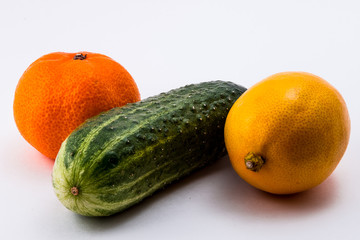 Изолированный зеленый огурец, желтый лимон и оранжевый мандарин на белом фоне