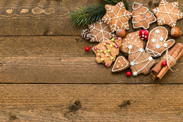 Gingerbread cookies, spices and fir branchon wooden background close-up