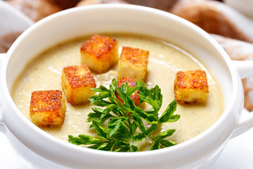 Vegetable soup with pieces of toasted bread and parsley.