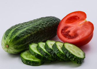 Изолированный красный томат и зеленый огурец на белом фоне