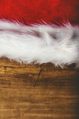 Retro toned Santa Claus hat on wooden desk