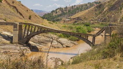 Old broken bridge on a muddy river