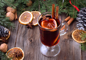 Mulled wine, sliced dried orange, cinnamon sticks, anise stars and candle with pine brunch