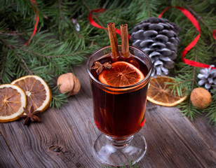 Mulled wine, sliced dried orange, cinnamon sticks, anise stars and candle with pine brunch
