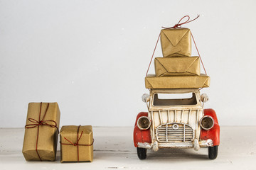 Gift boxes on toy vintage car, white background