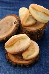 Homemade puff cookies on wooden stands on jeans cloth